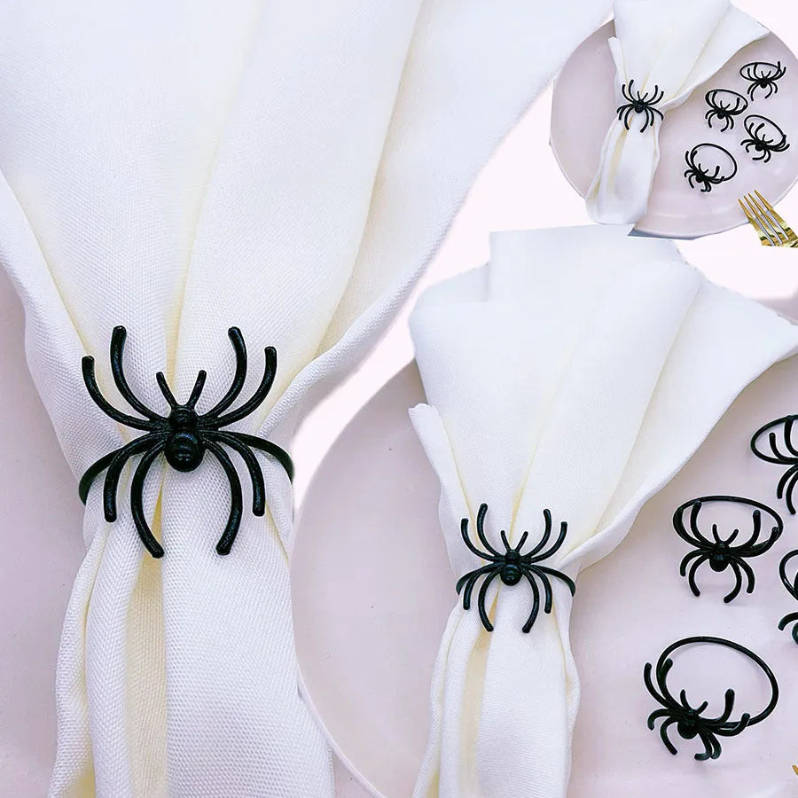 Six black alloy spider-shaped napkin rings for Halloween table settings.