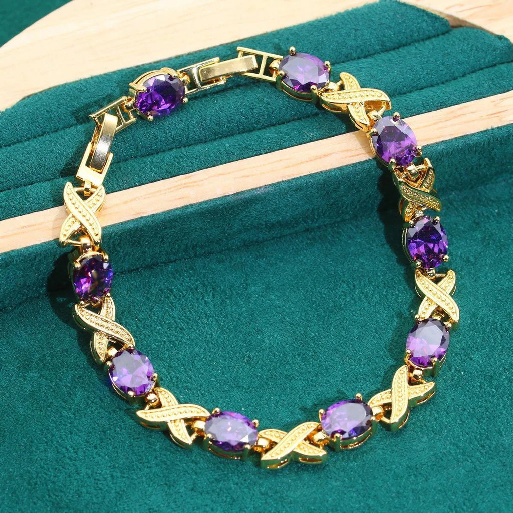 Gold-plated jewellery set with necklace, earrings, ring, and bracelet featuring blue cubic zirconia stones.