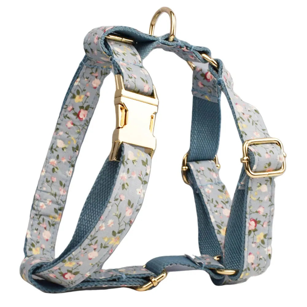 Blue floral patterned cloth dog collar with matching leash and vest set on a white background.