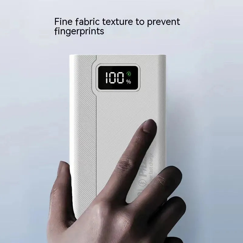 Black and white large capacity power bank with fast charging support, showing size scale.