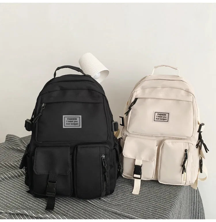 Black and white soft nylon student backpack showing external pockets and internal laptop compartment.