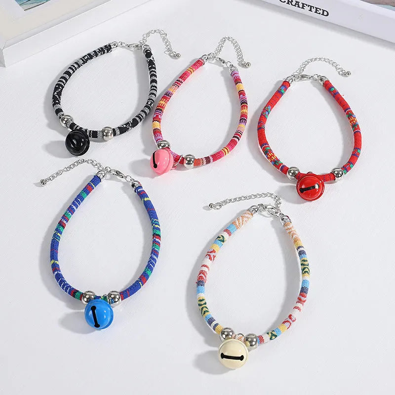 Coloured ethnic pattern adjustable pet collar for dogs and cats with a small metal bell attached.