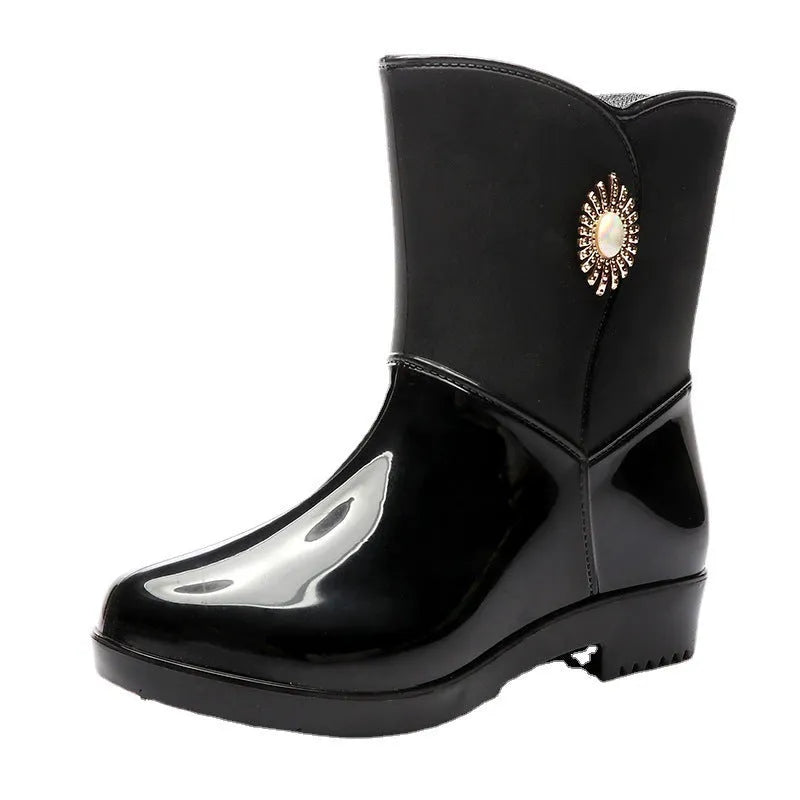 Women's purple PVC middle tube rain boots with a non-slip sole on a wet surface.