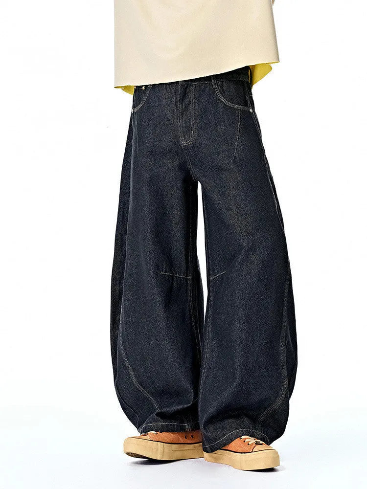 Men's wide leg denim trousers in original cow colour on a hanger, showing the relaxed fit and mid waist design.