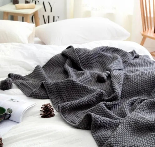 Nordic style fringed knit ball acrylic blanket in neutral colour on sofa