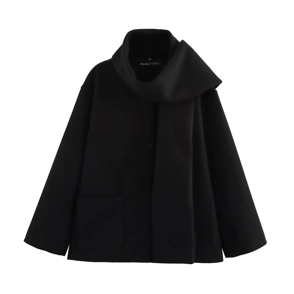 Women's long black overcoat with grey artificial fur collar, showing longline silhouette and pocket detail.