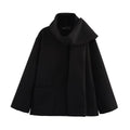Women's long black overcoat with grey artificial fur collar, showing longline silhouette and pocket detail.