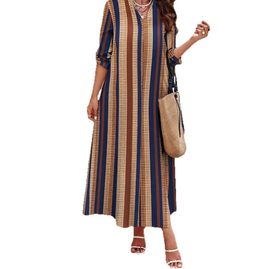 Camel coloured women's long dress with vertical stripes, a V-neck, and long sleeves on a mannequin.