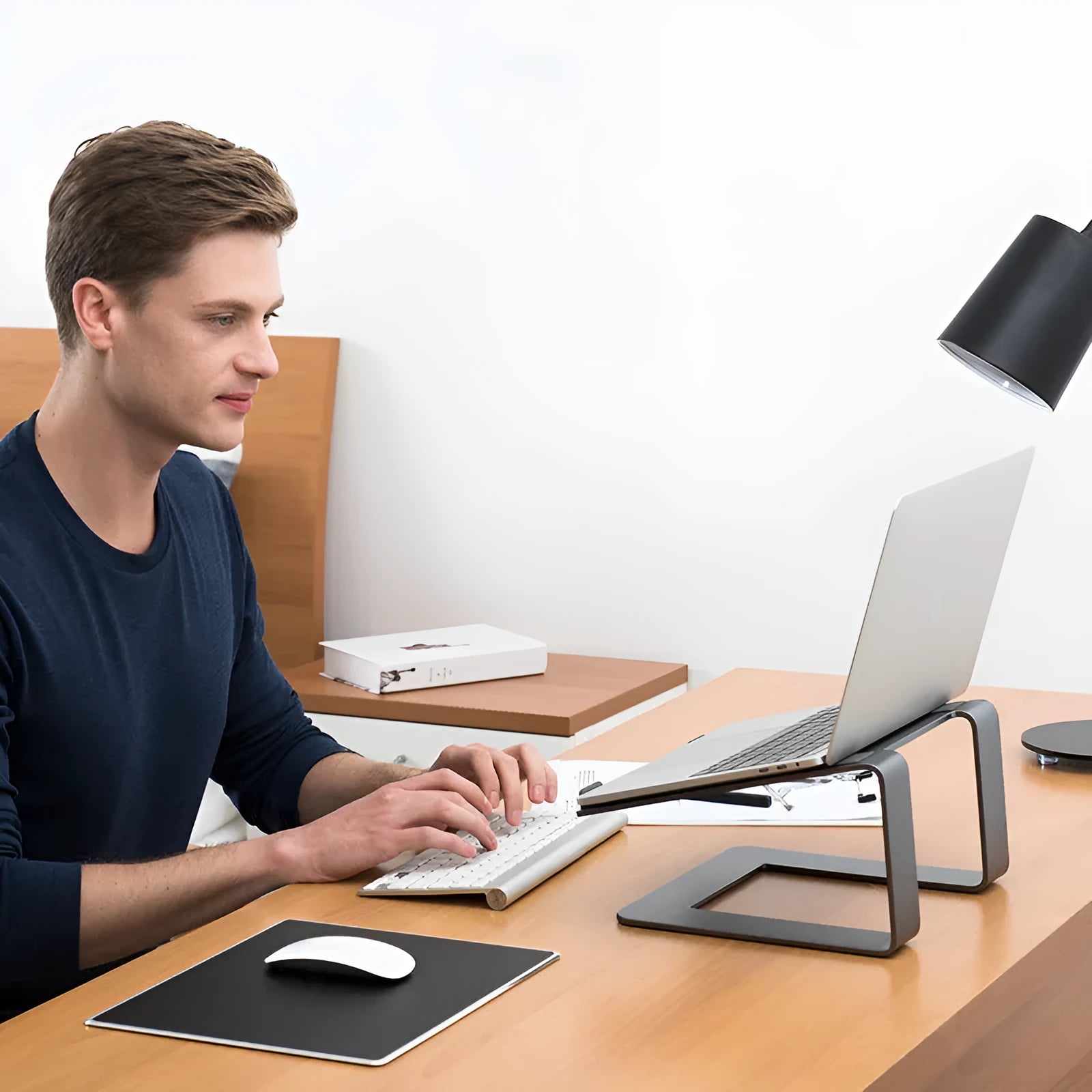 Black aluminium alloy laptop stand with open-frame design measuring 29.9cm wide on wooden desk
