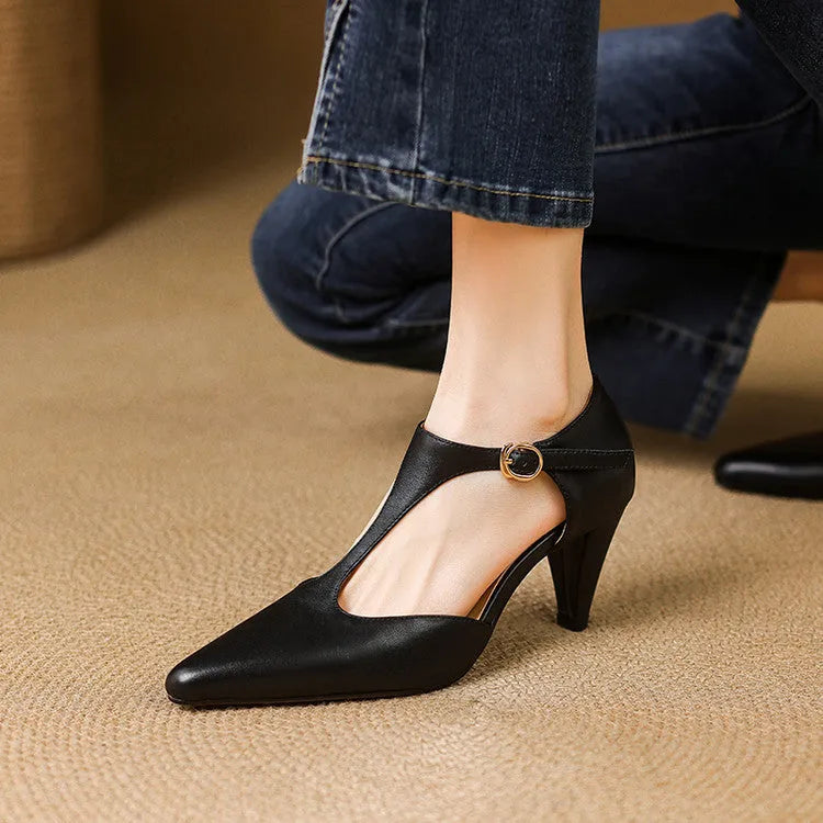 Brown retro women's T-strap closed toe sandals with a stout heel on a wooden surface.