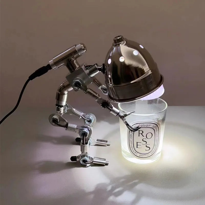 Silver copper robot-shaped table lamp with atmospheric lighting on study desk
