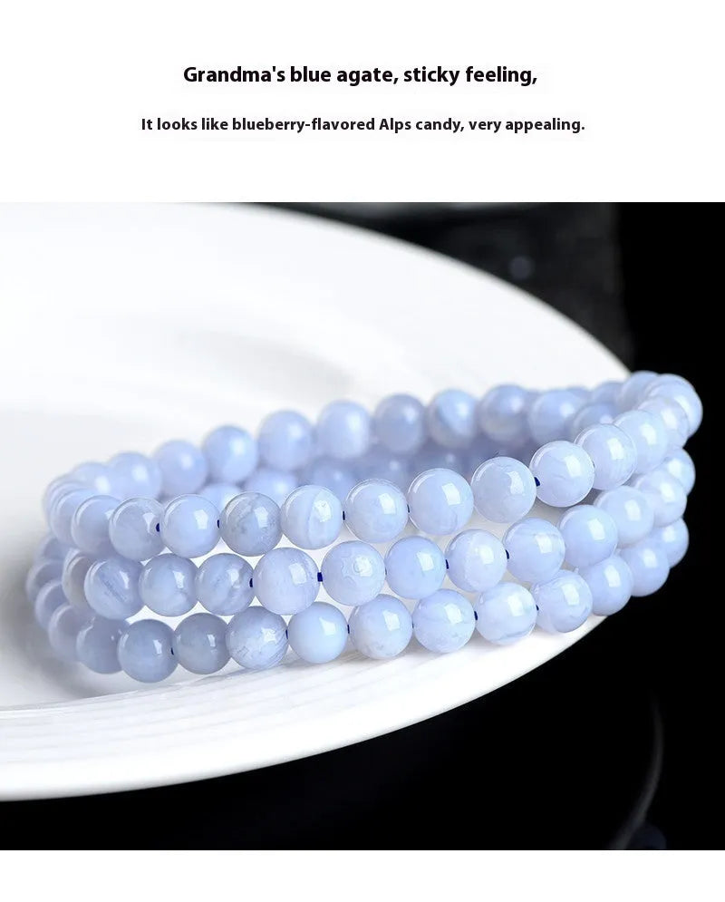 Close-up of a blue agate beaded bracelet with multi-circle pattern and scattered striped beads on a wrist.