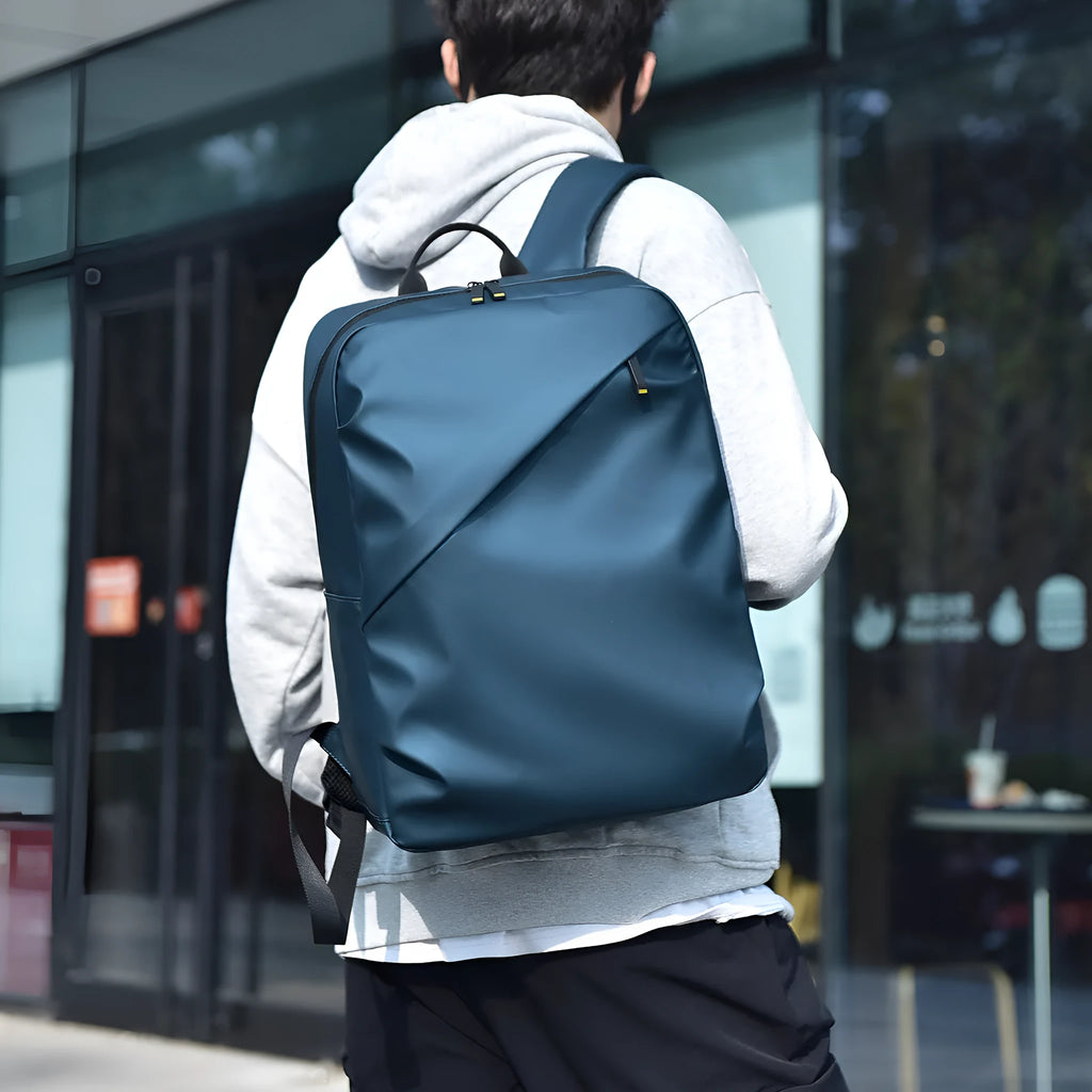 Large waterproof backpack in black with sewing thread detailing and included computer bag
