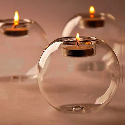 Handmade clear hollow glass sphere candle holder with tea light inside on wooden table