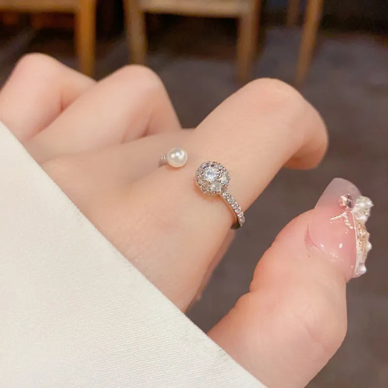 Golden round zircon open-end pearl ring with geometric shape on female hand