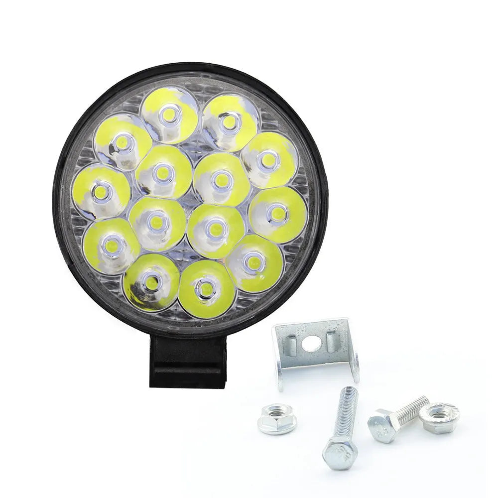 White mini round LED work light with aluminium housing, mounted as an auxiliary car or truck light.