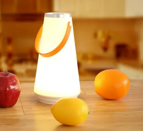 White rechargeable LED bedside table lamp with USB cable on a wooden surface.