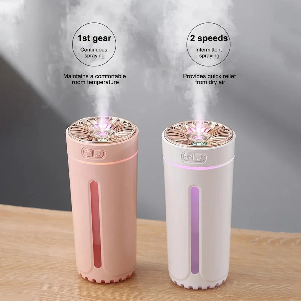 Compact black wireless humidifier with colourful LED lights sitting in car cup holder