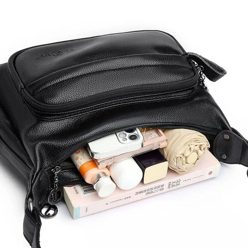 Large black women's shoulder bag with multiple compartments and luggage-inspired styling