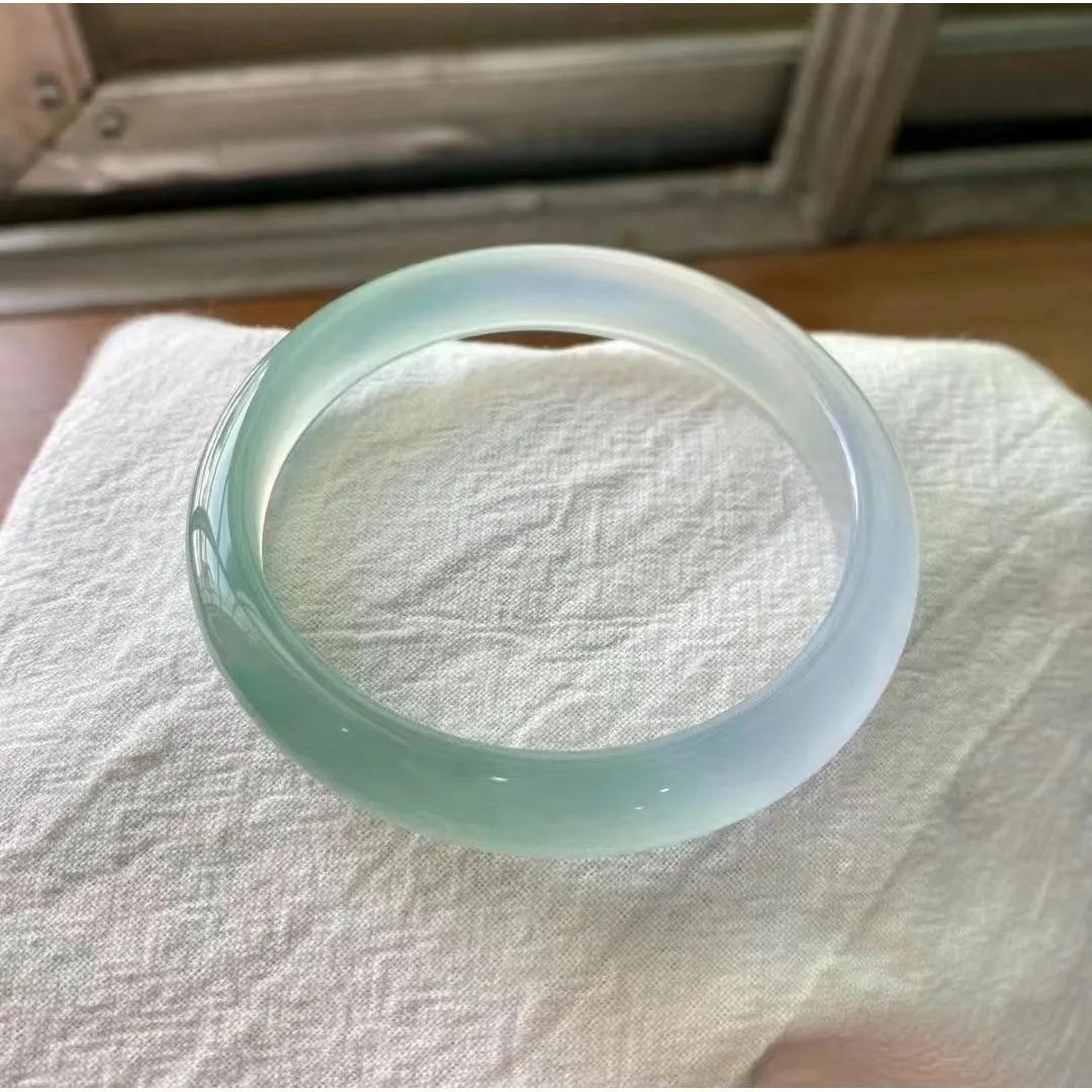 A natural agate wide tyre bracelet showing one of six colour options, such as pink or blue agate, on a wrist.