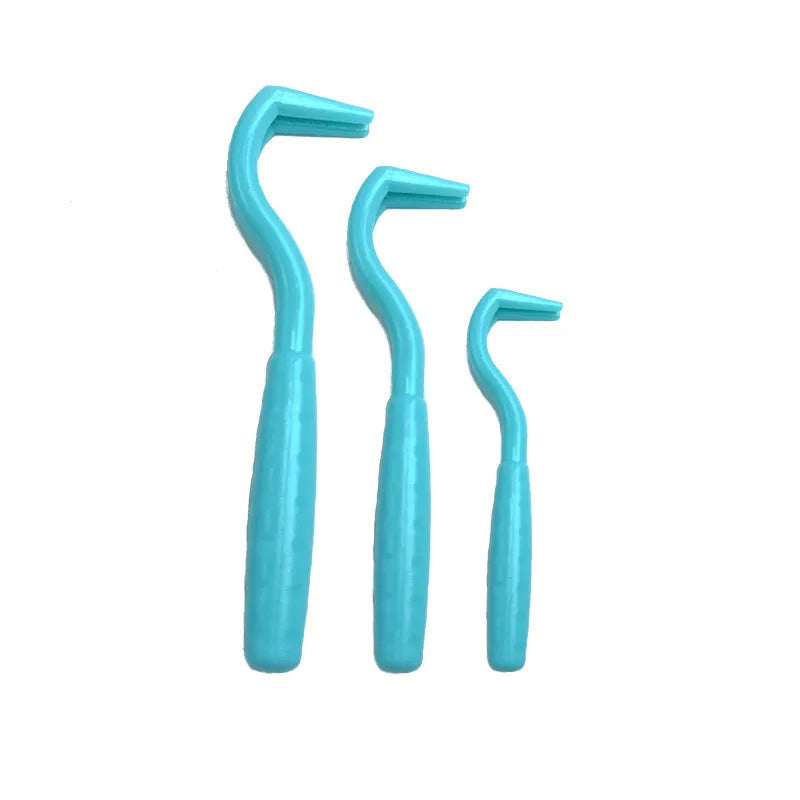 Set of three coloured plastic tick removal hooks for dogs on white background