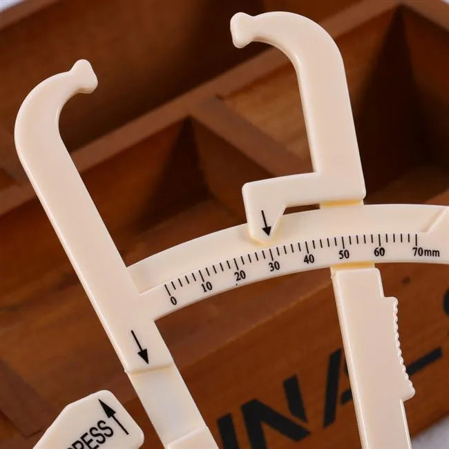 Acrylic body fat caliper measuring tool showing compact design and measurement scale