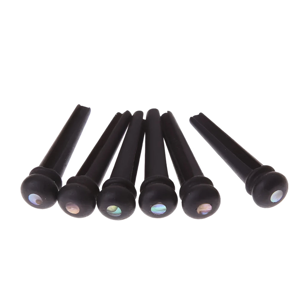 Set of six matt black ebony guitar bridge pins or string nails for acoustic guitar.