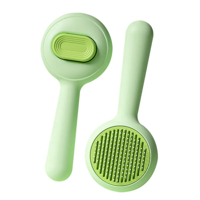 Green stainless steel cat grooming brush with non-slip handle removing loose pet hair