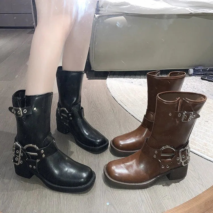 Women's black leather platform boots with a silver belt buckle, shown from the side.
