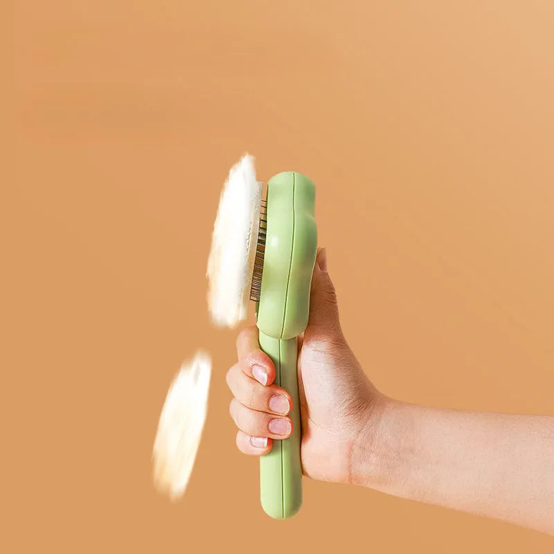 Green and yellow self-cleaning cat comb with stainless steel needles for pet grooming.