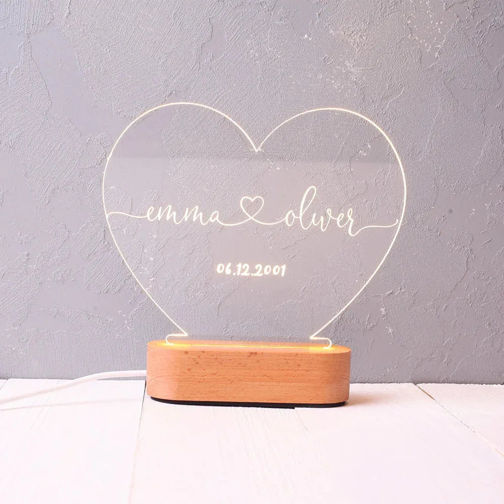 Custom engraved acrylic night light displaying personal names and a date, lit from a base LED.