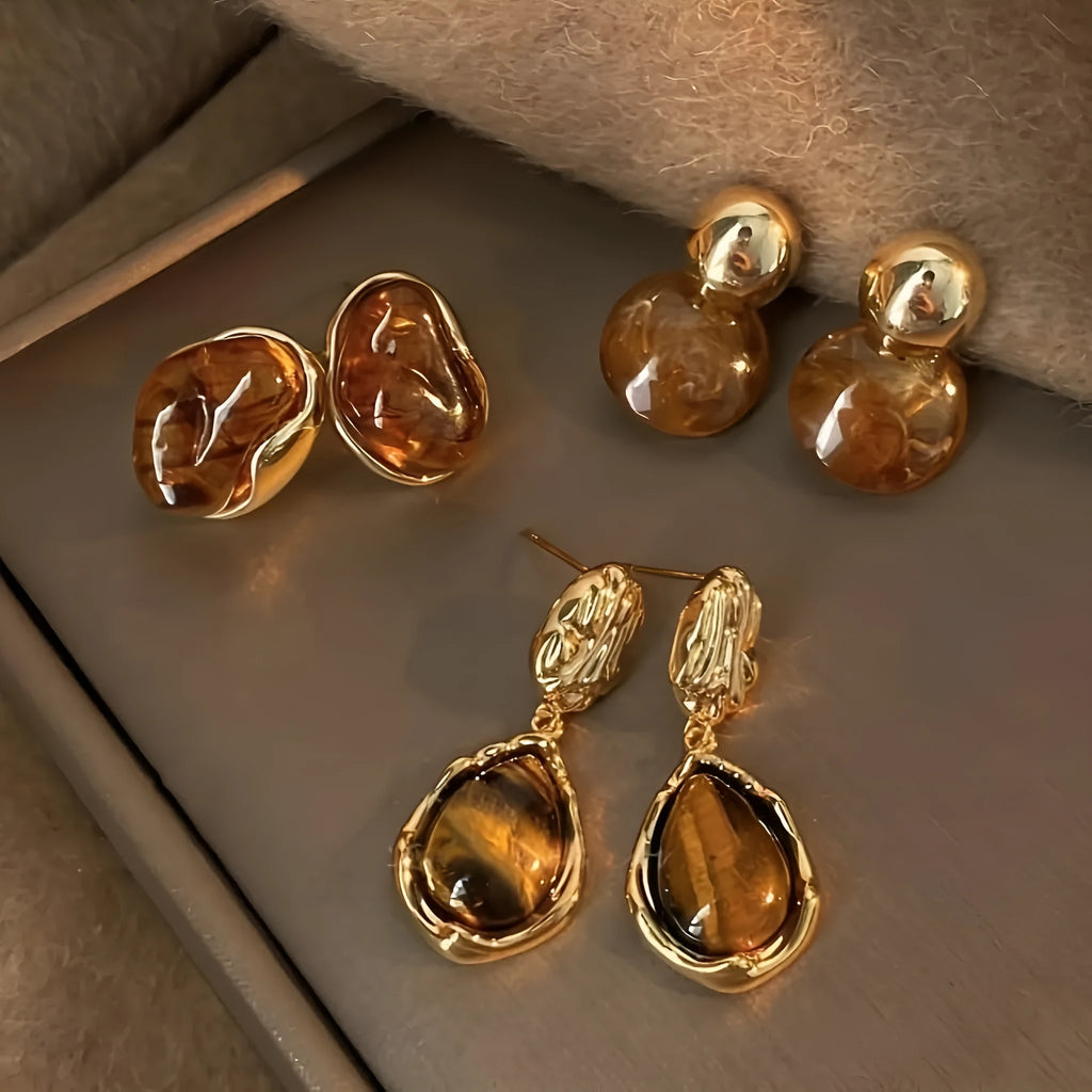 Three pairs of geometric alloy earrings with electroplated finishes in irregular amber, wafer round, and water drop tassel styles
