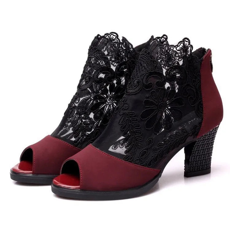 Women's black lace-up gladiator sandals with a square high heel and decorative floral detail on the peep toe