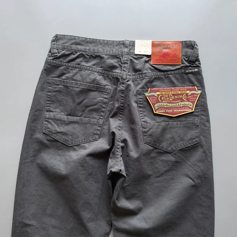 A pair of men's straight leg casual trousers in khaki colour on a mid-grey background.