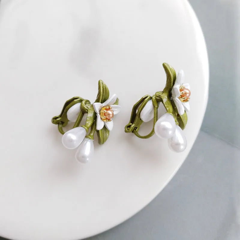 A pair of women's alloy flower-shaped clip-on earrings with contrasting sterling silver needle floral details.