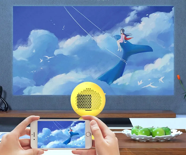 YG220 portable LED projector in white or yellow colour on a table projecting a movie scene.