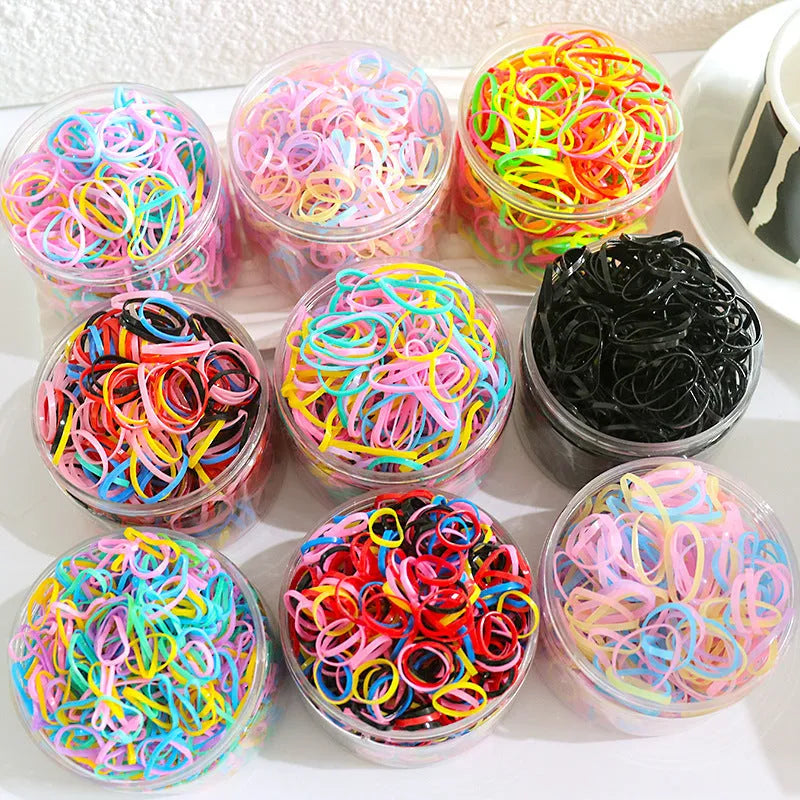 Multi-colour TPU baby hair ties in a reusable plastic storage container.