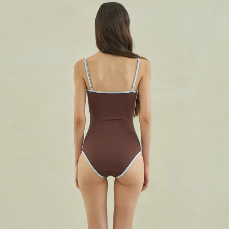 Brown triangle-style one-piece swimsuit for women on a hanger.