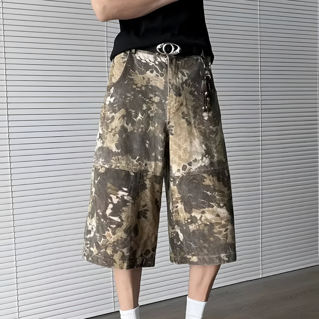 Yellow snake camouflage pattern on cropped denim jeans laid flat.
