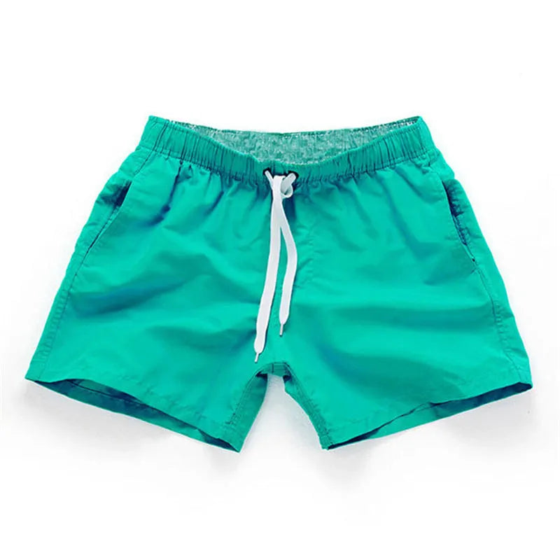 Men's straight-leg polyester beach shorts on a hanger, showing the classic fit and available in multiple solid colours.