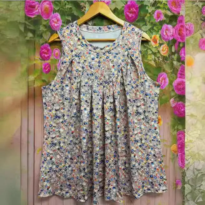 A black plus size sleeveless vest with a floral print, shown on a hanger.