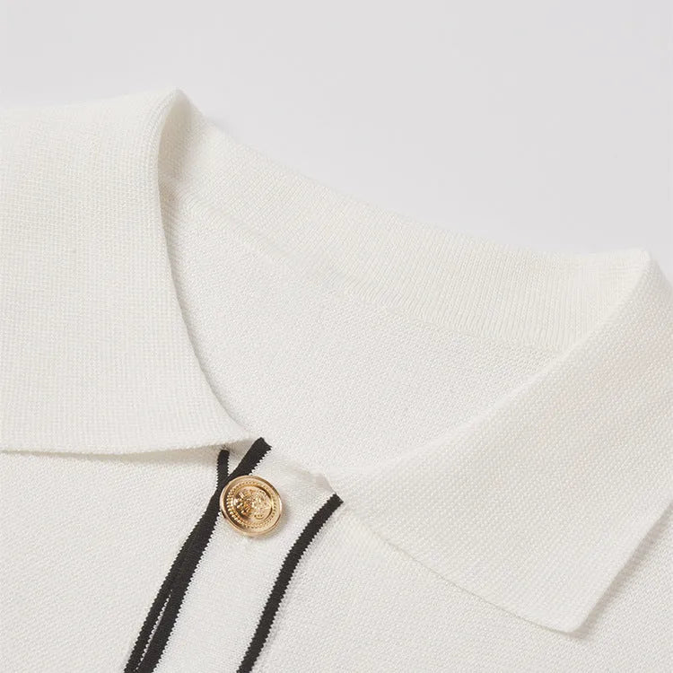 White women's short sleeve cardigan with dark contrast lapels on a hanger.