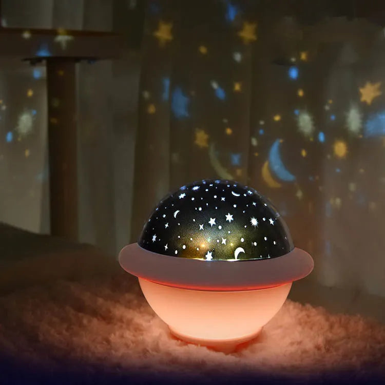Green UFO-shaped plastic LED night light projecting starry sky pattern on a dark wall