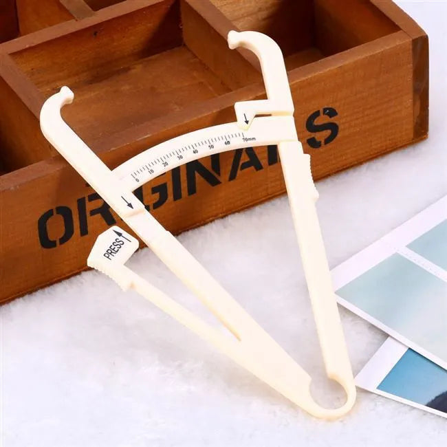 Acrylic body fat caliper measuring tool showing compact design and measurement scale