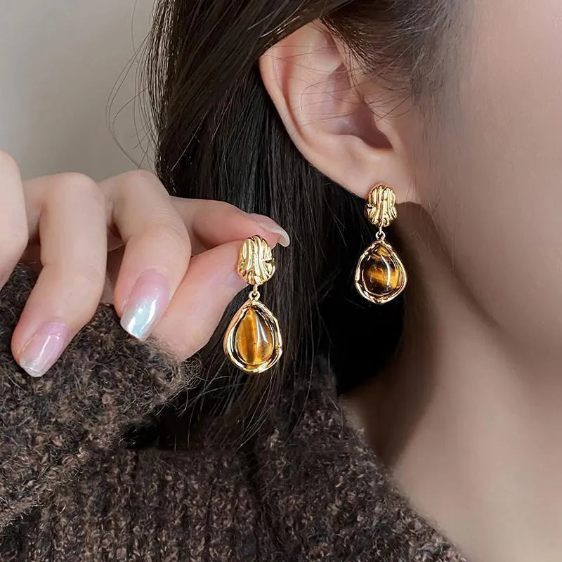 Three pairs of geometric alloy earrings with electroplated finishes in irregular amber, wafer round, and water drop tassel styles