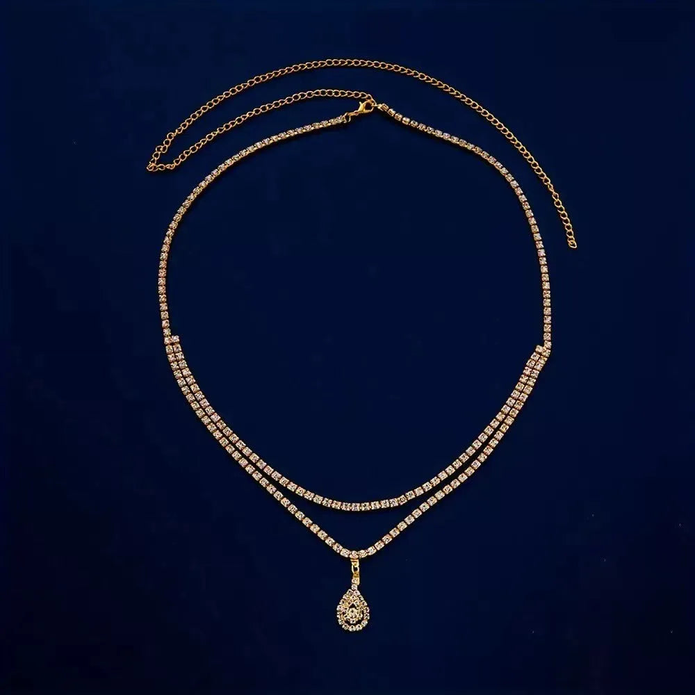 Gold waist chain with water drop pendant and rhinestone details, showing lobster clasp closure