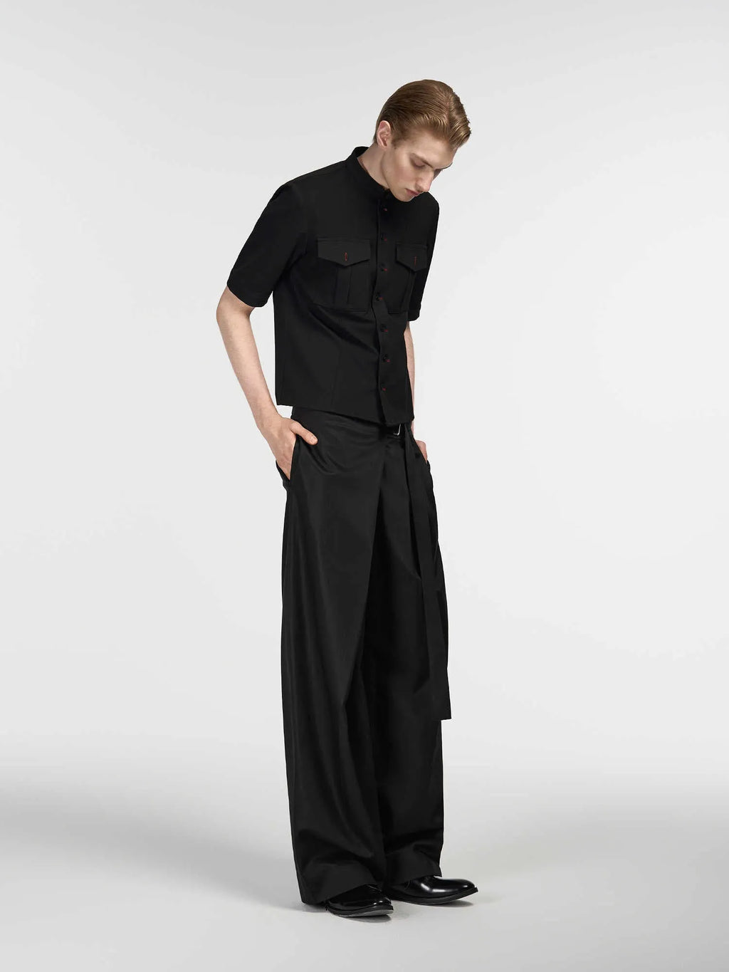 Black straight-leg trousers made from Tencel and cotton blend with a single pleat and adjustable waistband.