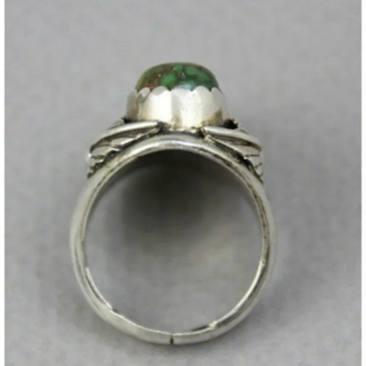 Close-up of a geometric alloy ring with a retro turquoise inlaid centre on a model's hand.