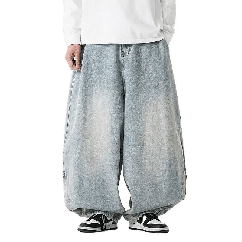 Men's plus-size baggy blue jeans with a wide leg and straight hem on a casual background.