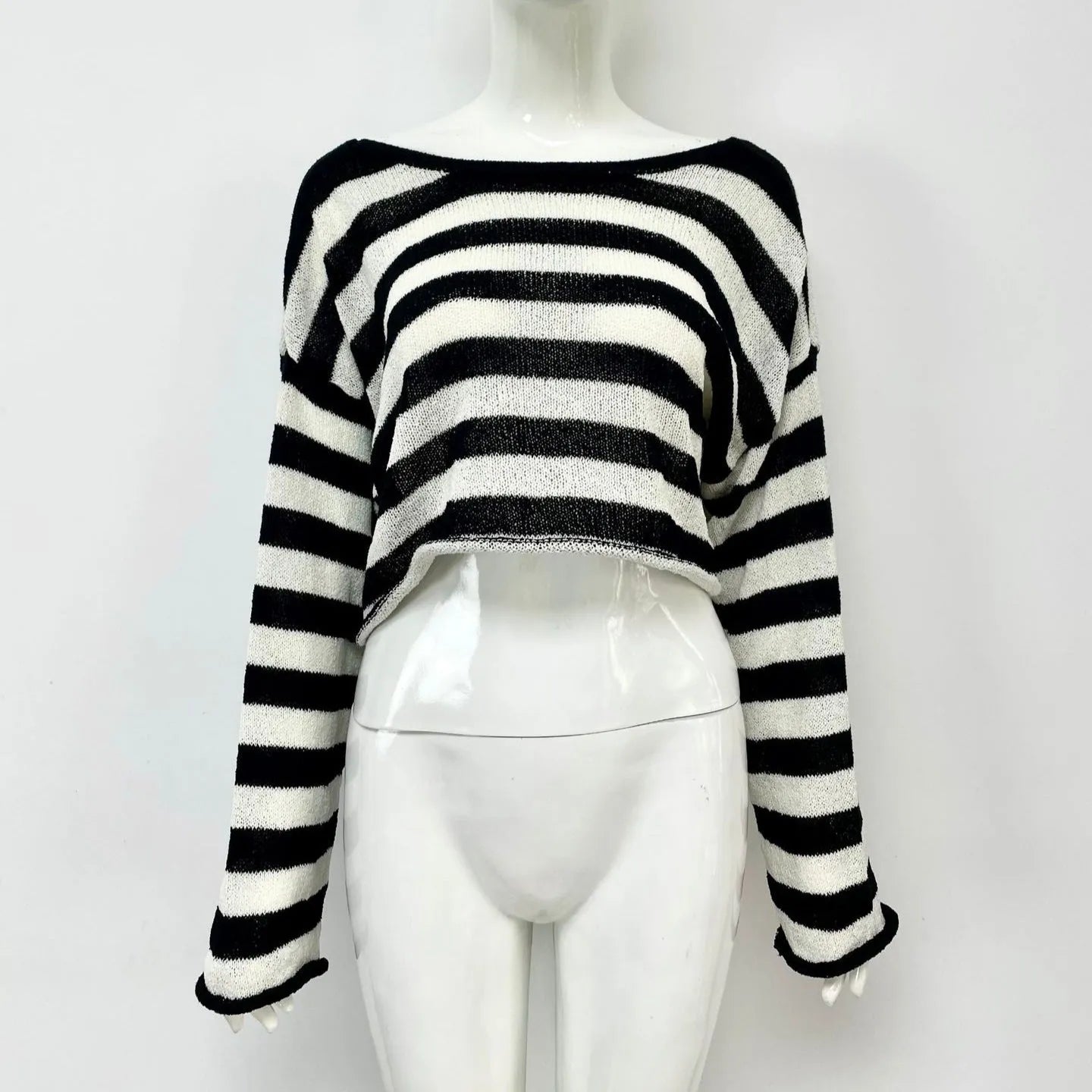 Woman wearing a striped cropped long-sleeved sweater in coloured cotton, showcasing the front and back wearable design.